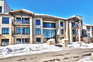 A multi-story building with a stone facade, large windows, and balconies. - Blackstone 2BR/2.5BA | Two King Suites | Pool & Hot Tub | Canyons Village (Park City)