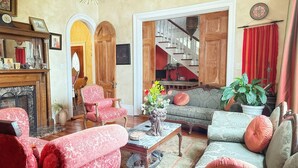 A traditional living room with a fireplace, a staircase, and a dining area. - Whole House Rental in Virgina (Lynchburg)