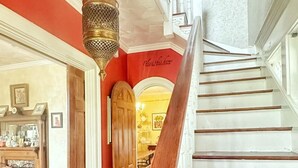 A grand staircase with a wooden handrail and white steps, leading to an upper level. - Whole House Rental in Virgina (Lynchburg)
