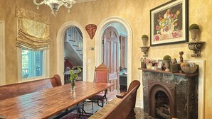 A dining room with a wooden table, benches, and a fireplace. - Whole House Rental in Virgina (Lynchburg)