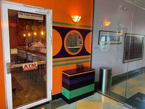 Welcome to the hotel lobby, featuring a vibrant wall, circular mirror, and decorative pattern.