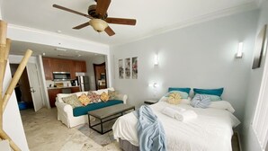 A bedroom with a bed, bedside tables, a sofa, a coffee table, and a ceiling fan. - Right on the Beach Ocean Dr Secured Condo 206 (Miami Beach)