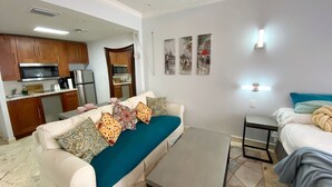 A living room with a sofa, a coffee table, a bed, and a kitchen area. - Right on the Beach Ocean Dr Secured Condo 206 (Miami Beach)