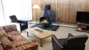 A living room with a fireplace, a sofa, a coffee table, and a TV stand.