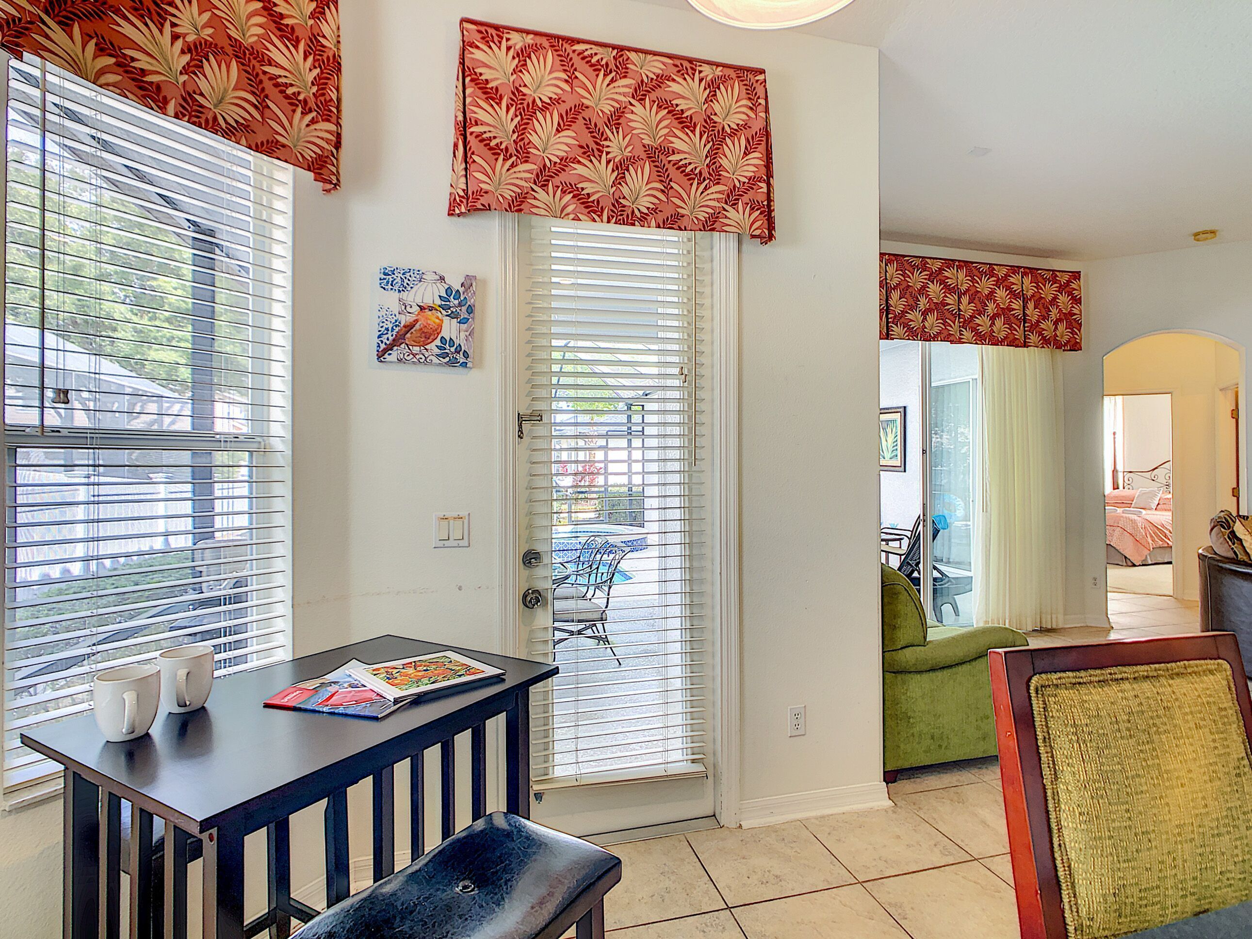 A room with a dining table, bench, and a door leading to another room.