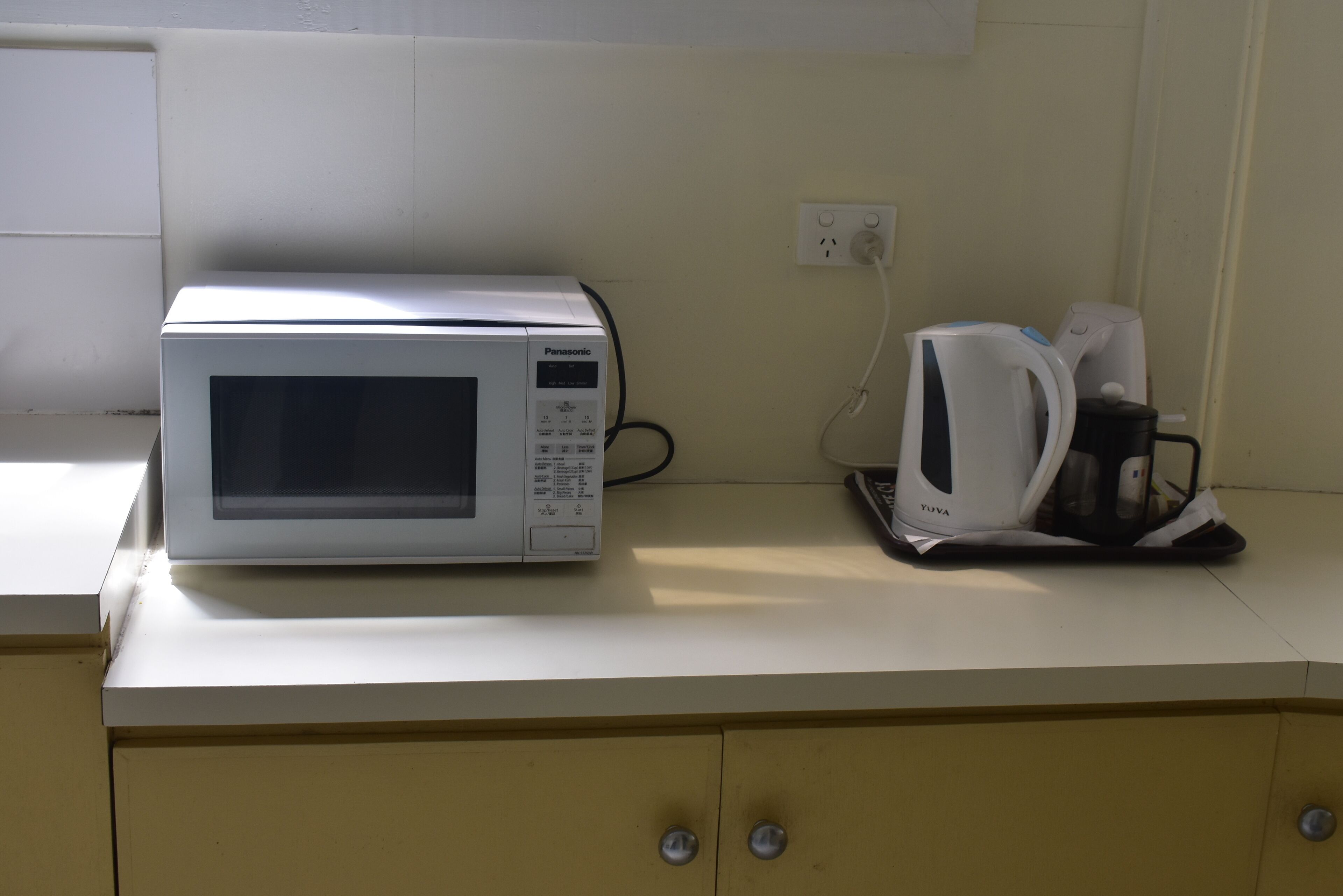 A microwave and a coffee maker on a kitchen counter.