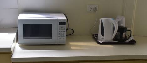 A microwave and a coffee maker on a kitchen counter.