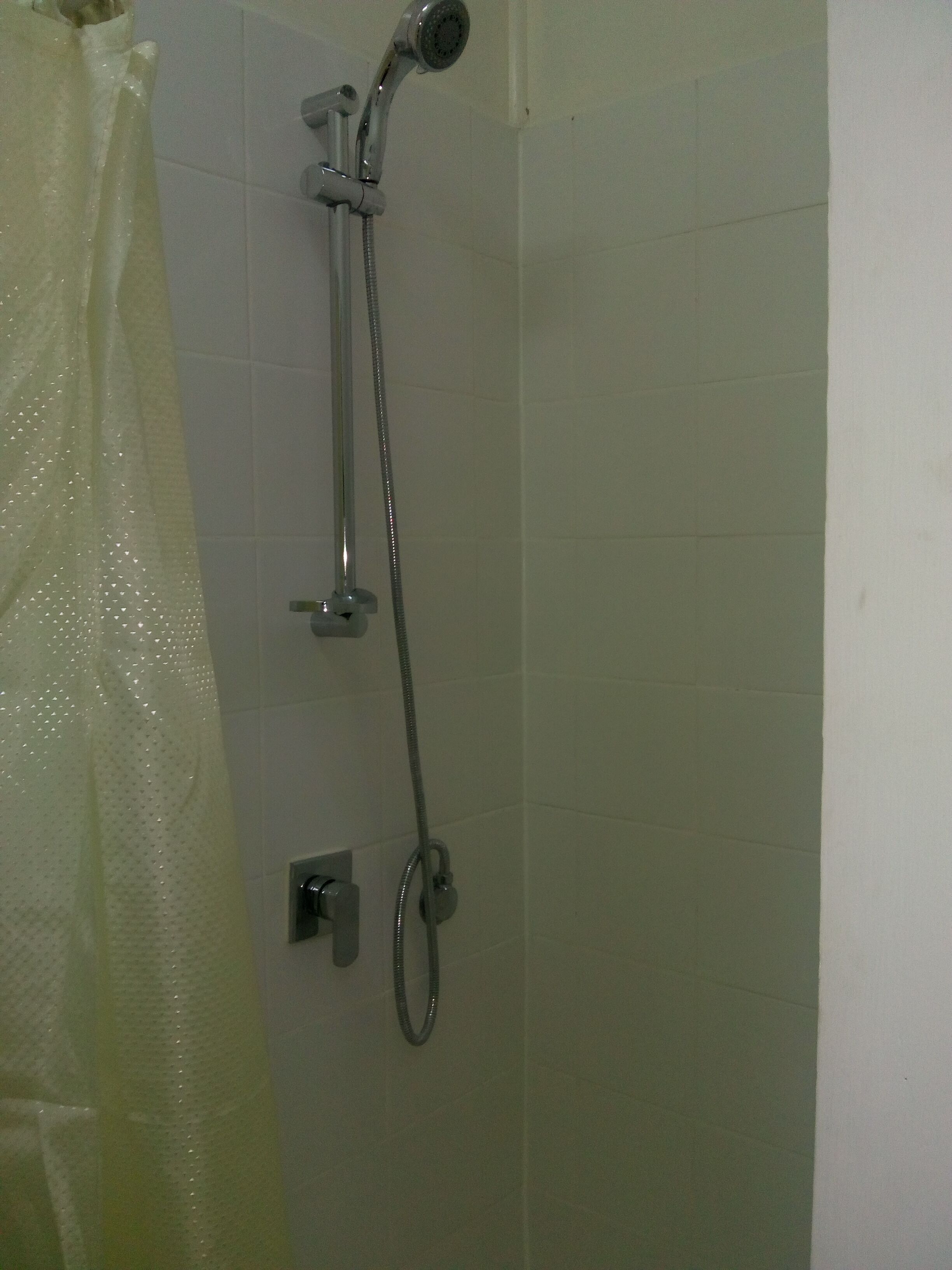 A shower with a handheld showerhead and a fixed showerhead.