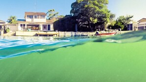 Zona residencial con casas, un muelle y una persona en un bote.