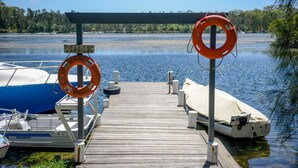 Un molo di legno con due galleggianti di salvataggio e un cartello che indica 'PRIVATE KEEP OFF'. Imbarcazioni ormeggiate a sinistra.
