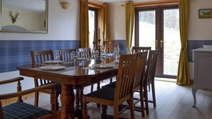 Comedor con mesa de madera dispuesta para cuatro personas, rodeado de sillas.