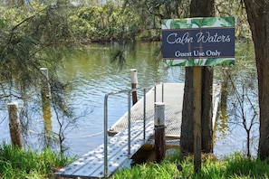 Un muelle con un letrero que dice "Caml Waters Guest Use Only" en un entorno natural.