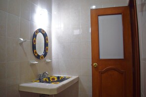 A bathroom with a sink, mirror, and door. - Hotel Hacienda Sanchez (Valladolid)