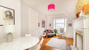 A well-lit living room with a white table, chairs, a sofa, and a fireplace. - Stunning Apartment in Royal Mile (Edinburgh)