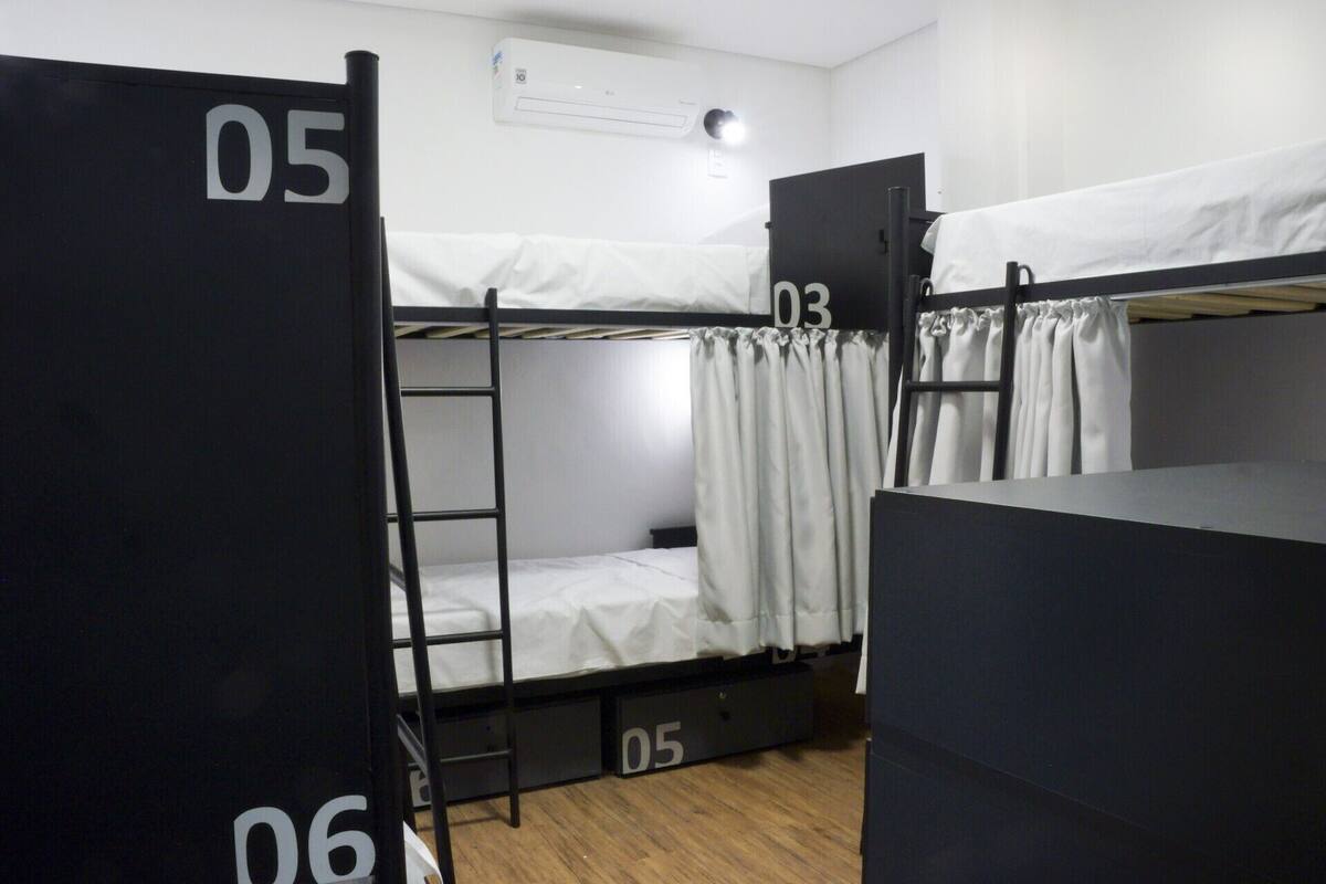 A dormitory room with bunk beds labeled 05, 03, and 06.