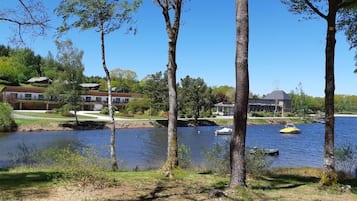 Una propiedad frente al lago con una casa, un muelle para botes y una vista despejada del agua.