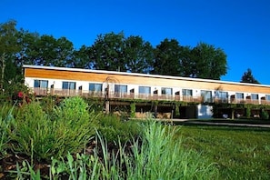 Un bâtiment moderne doté d’un toit plat, de nombreuses fenêtres et d’une terrasse en bois.