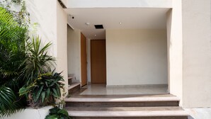 Una entrada limpia y moderna con una escalera de madera que lleva a una puerta.