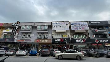 A street view with multiple commercial buildings, including a hotel, a store named 'Orange Premier,' and a 'Chaggee' store.