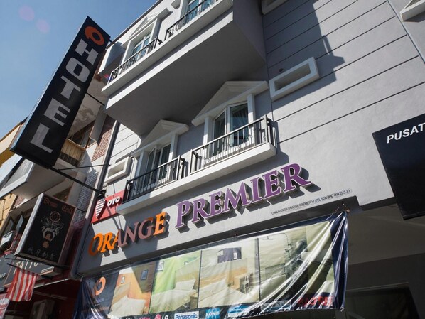 Un hôtel appelé Orange Premier, doté d’un balcon et d’une enseigne pour Demon Craft et OYO.