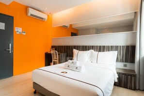 A hotel room with a bed, a desk, an air conditioning unit, and a mirror. - Orange Premier Hotel Taman Segar (Kuala Lumpur)