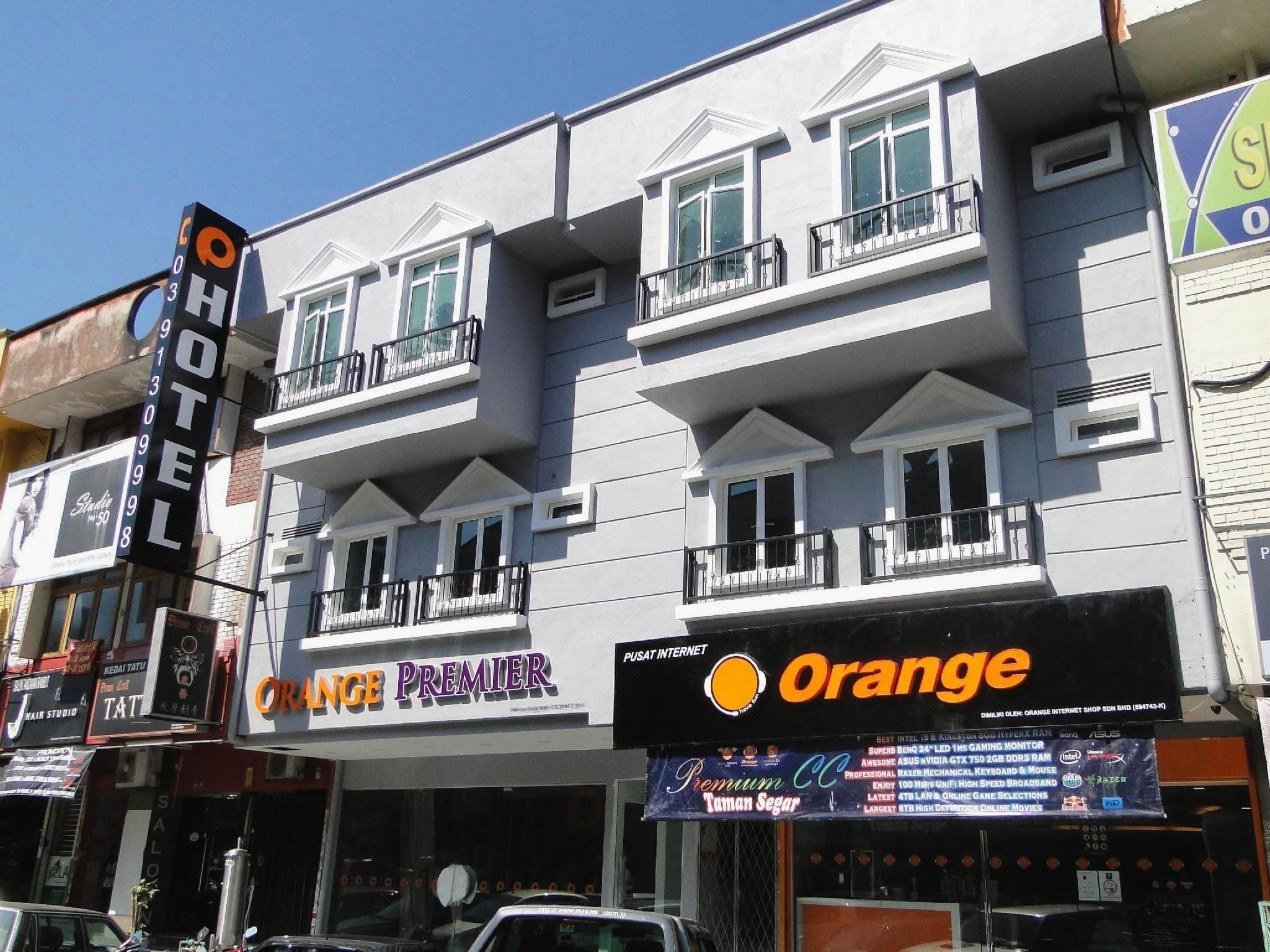 Un hotel con varios pisos, balcones y diferentes letreros comerciales.