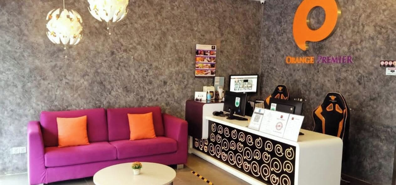 A reception area with a purple sofa, a white table, and a patterned counter.