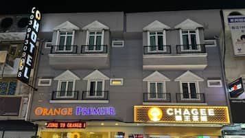 A hotel facade with signage for 'Orange Premier' and 'Chagee' restaurants.
