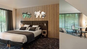 Una habitación de hotel moderna con una cama grande, un cabecero de madera, un espejo montado en la pared y una pequeña mesa con sillas.