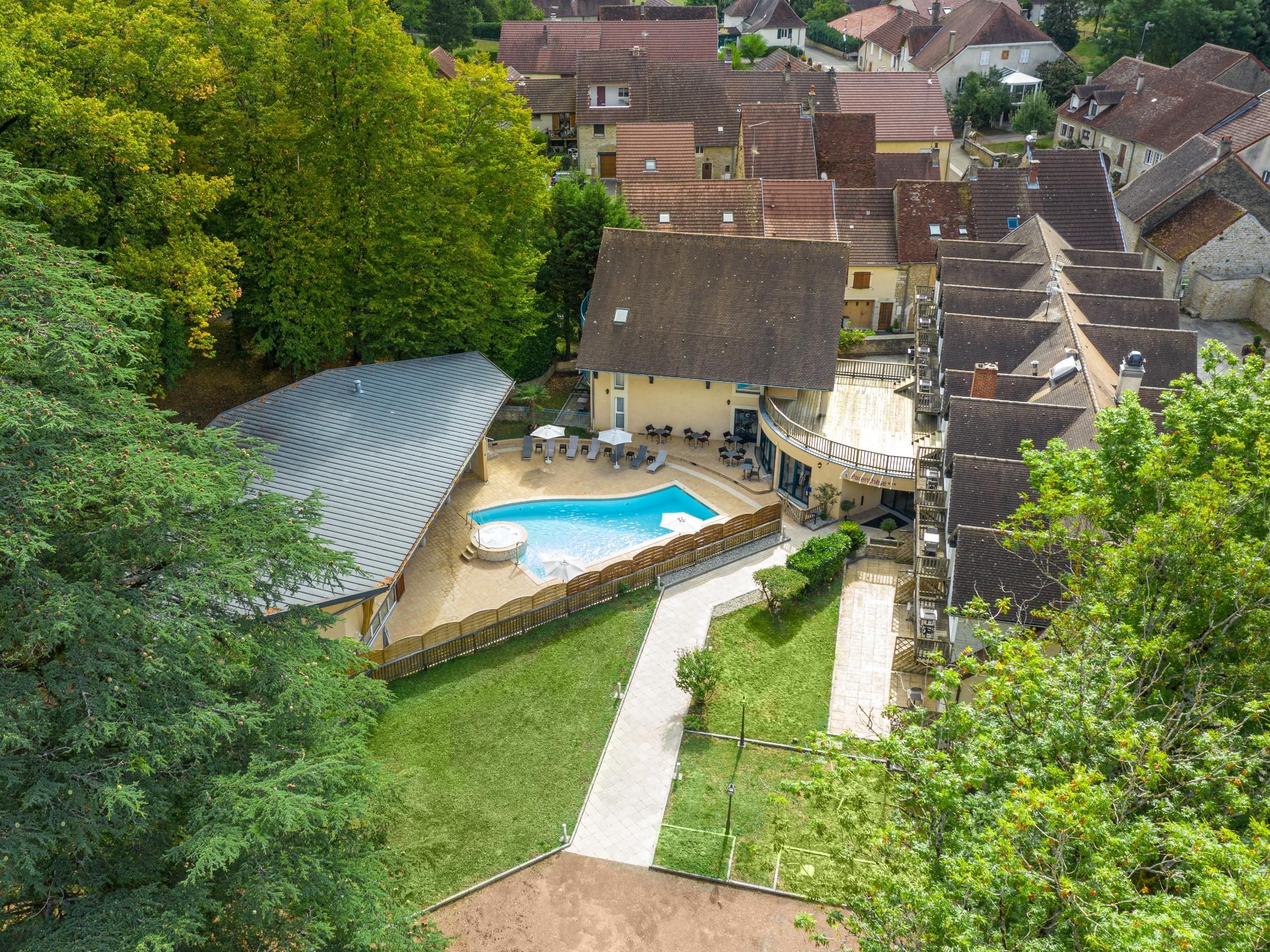 Ein Wohnhaus mit Schwimmbad, überdachter Terrasse und umzäunter Garten.
