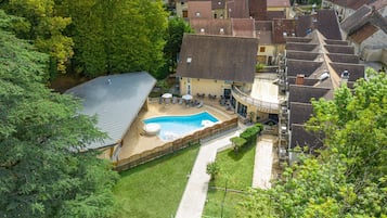 Ein Wohnhaus mit Schwimmbad, überdachter Terrasse und umzäunter Garten.