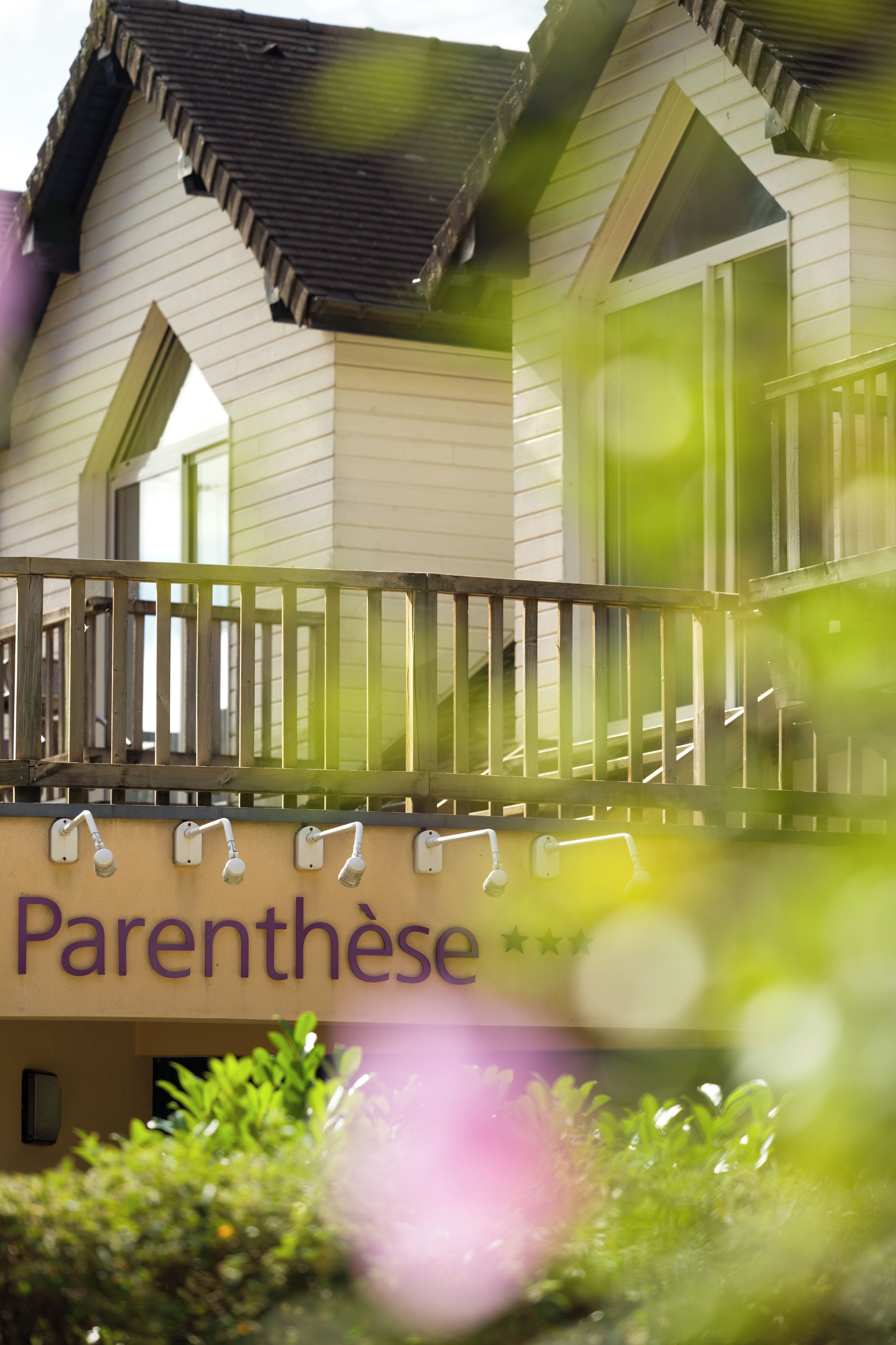 A building with a balcony, a sign with the word 'Parenthèse,' and a window.
