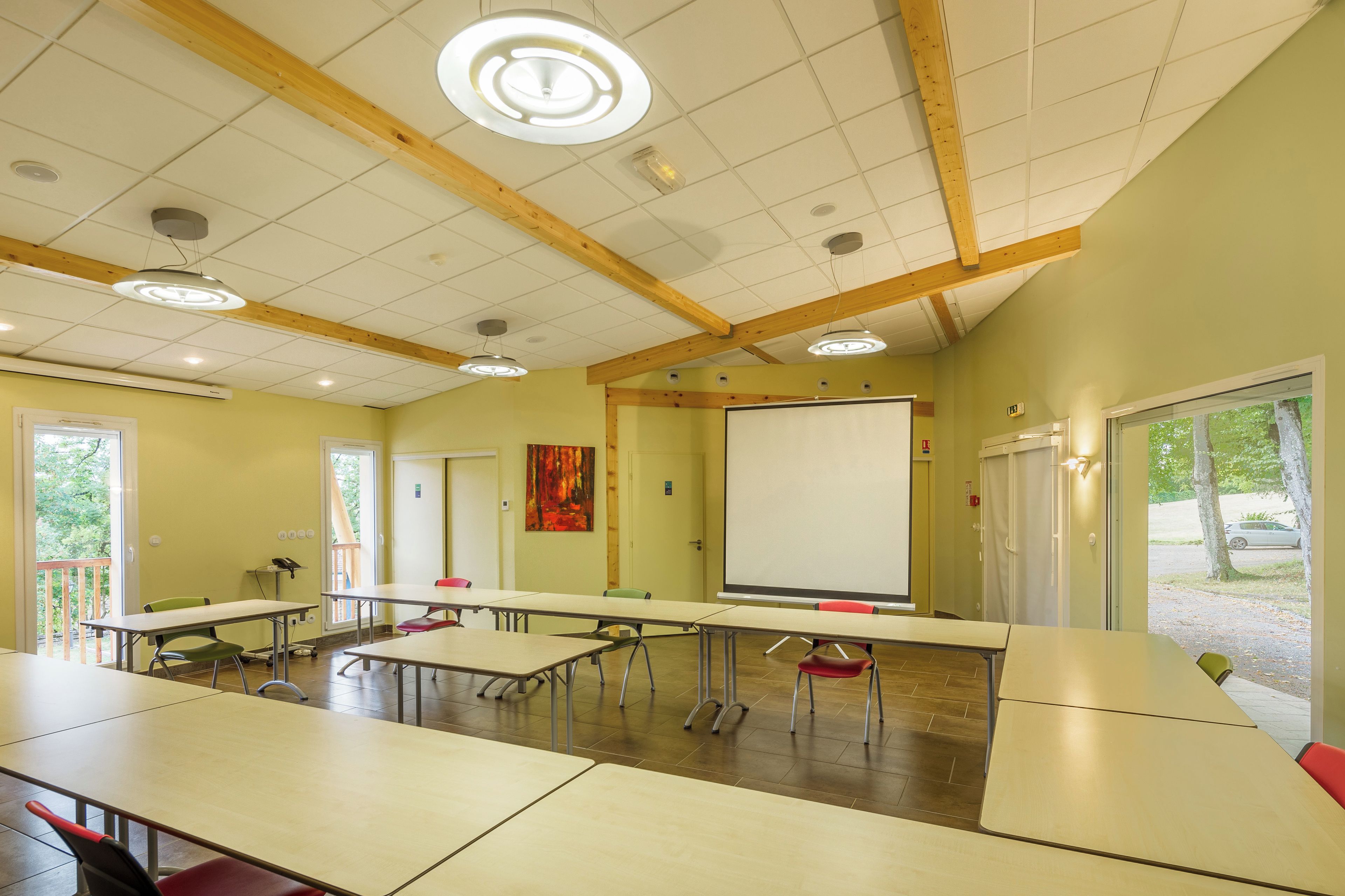 A conference room with tables, chairs, a whiteboard, and a large window.