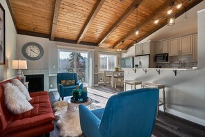 A modern living room with a red sofa, blue armchair, and a fireplace. - SeaTac Condo Close to Everything! (Tukwila)