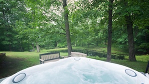 A hot tub surrounded by a lush green forest.