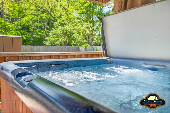 A hot tub with a wooden deck and a wooden fence in the background. - Log cabin, pets, close to Nashville. (Nashville)