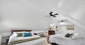A bedroom with two beds, a ceiling fan, a nightstand with a lamp, a chair, and a window with a view. - Pet friendly, secluded, close to Nashville! (Nashville)