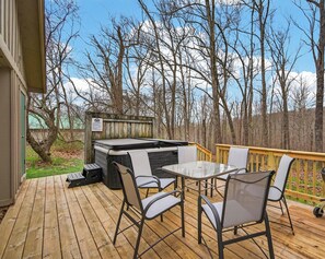A wooden deck with a hot tub, outdoor seating, and a view of trees and mountains. - Pet friendly, secluded, close to Nashville! (Nashville)