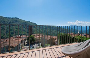 Enjoy the serene village view from this balcony with a comfortable seating area.