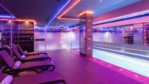 Eine moderne Hotelhalle mit Poolbereich, Liegestühlen und einer Rezeption.