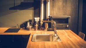Eine Küche mit Holzarbeitsplatte, Spüle, Herd und Kaffeemaschine.