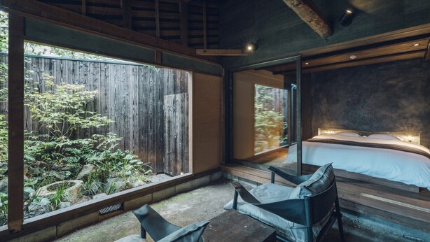 A bedroom with a large window, a bed, and a seating area. - Meguru House Kyoto (Kyoto)
