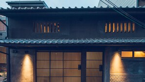 A traditional Japanese house with a tiled roof, a wooden gate, and a brick wall. - Meguru House Kyoto (Kyoto)