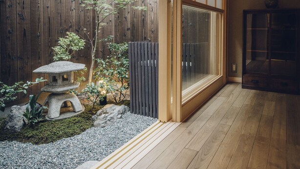 A traditional Japanese interior with tatami flooring, a shoji screen, and a small garden area with a stone lantern and bonsai tree. - Someno House Kyoto Dog Friendly (Kyoto)