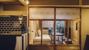 A traditional Japanese-style room with tatami flooring, a low wooden table, and a sliding door with a grid pattern. - Someno House Kyoto Dog Friendly (Kyoto)