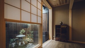 A traditional Japanese interior with tatami flooring, a sliding door, and a small garden view. - Someno House Kyoto Dog Friendly (Kyoto)