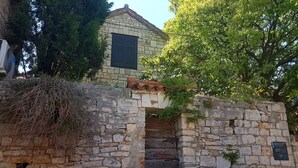 A stone building with a tiled roof and a wooden door. - Apartment Nadja -Studio with Terrace (Supetar)
