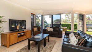Ein modernes Wohnzimmer mit Fernseher, Sofa und Couchtisch.