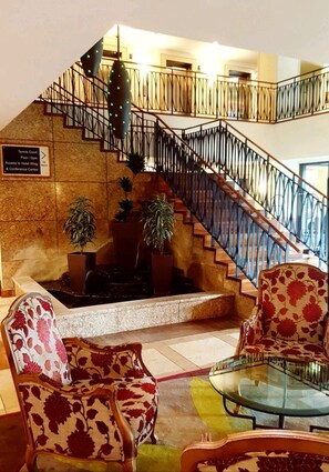 Step into the grand lobby, where a sweeping staircase leads to the upper level and offers access to the tennis court, pool, gym, and more.