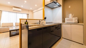 Een moderne keuken met een centraal eiland, roestvrijstalen apparatuur en een magnetron op een kast.